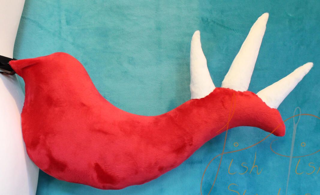 A red base and cream spiked allosaurus inspired dinosaur tail. This one sits about 21 inches long and sticks out from the wearers body. handmade in the UK by fishpish Studios