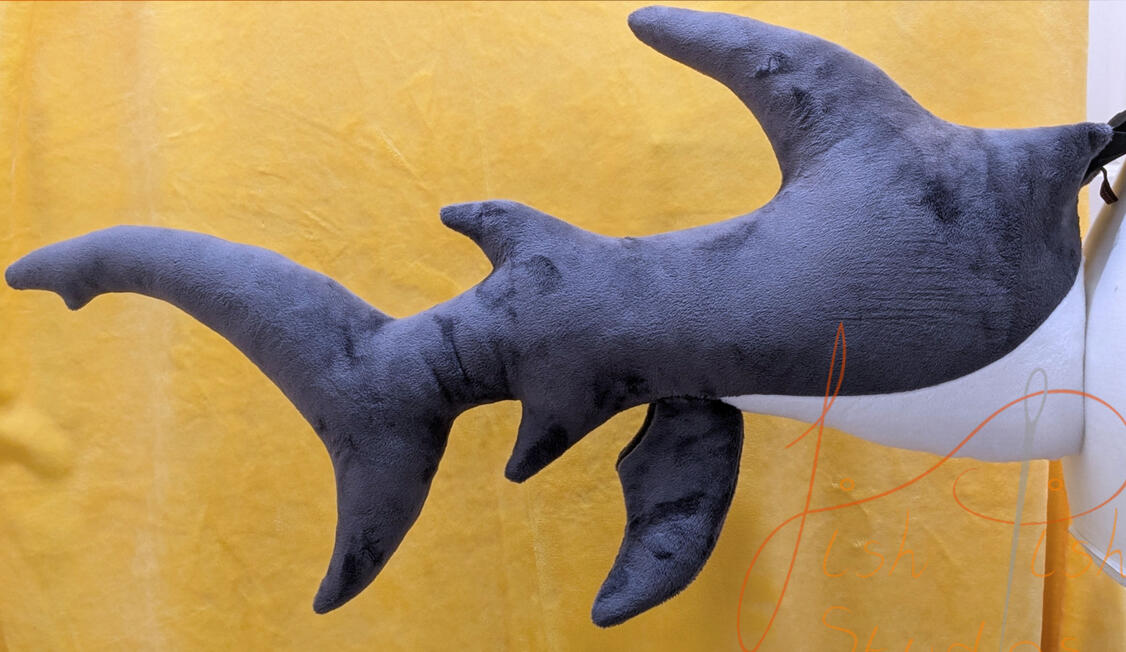 A 27 inch long dark grey and white shark tail made of soft plush fabric. It connects to a belt using belt loops and is available in a wide range oc colour combinations. Available via our store, they are handmade by fishpish studios
