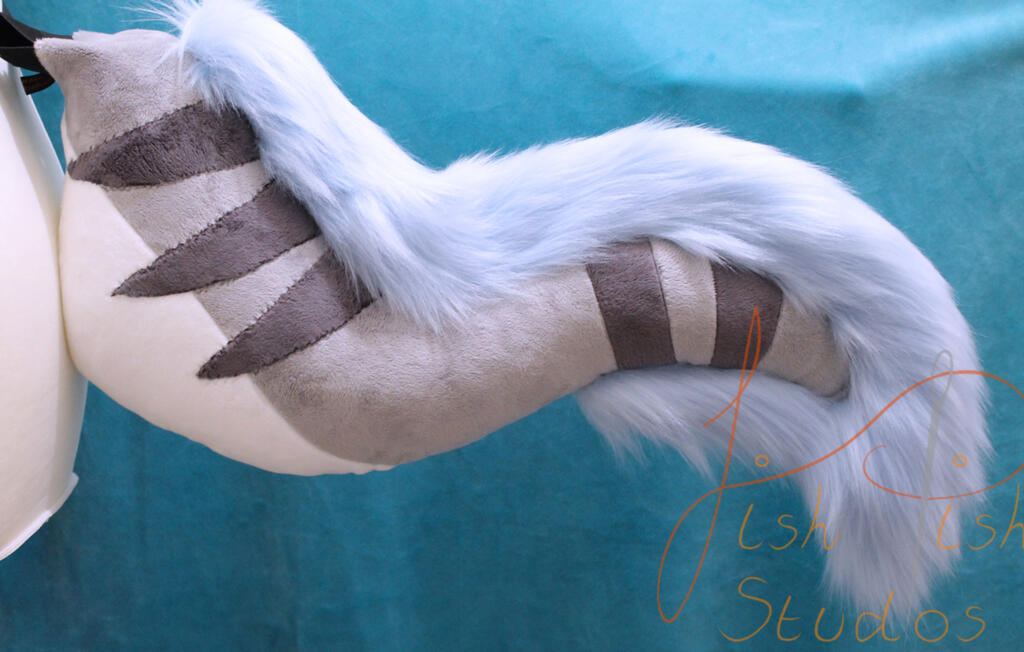 a competition prize won on bluesky. it's made of various grey and cream minky/soft plush fabrics and a baby blue luxury faux fur. it sticks out about 21 inches, and is soft to the touch. designed by the winner and made by fishpish studios