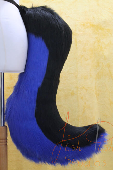 Large Wolf Tail A larger 25 inch long drop wolf tail which attaches to a belt using belt loops. It is made from luxury faux fur, this one it two colours with the top being black and the the base or underside being a royal blue. It is handmade in the UK by FishPish Studios