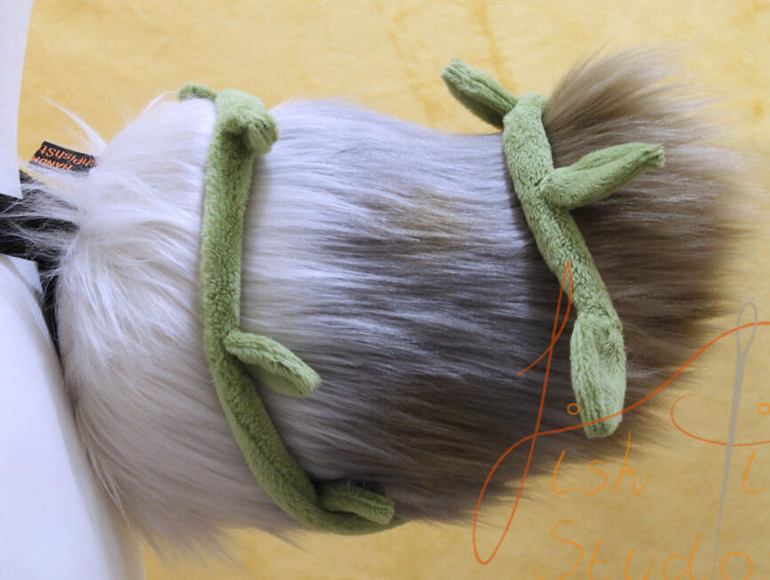 A custom made faux fur deer tail with removeable leaves and vine A custom made faux fur deer tail with removeable leaves and vine. This was made as a competition prize on Bluesky. It is made from various shades of creams and brown faux furs, with a green, wire cored vine wrapped around it. designed by the winner and mad